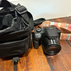 Canon PowerShot
SX540 HS with bag, battery, and strap.